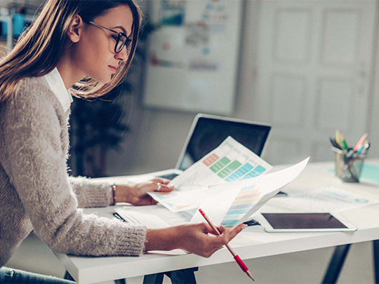Une salariée consultant des documents devant son ordinateur, pour illustrer le coaching individuel en entreprise. C'est une des prestations proposées par Marion Massardier avec Wellcome Back